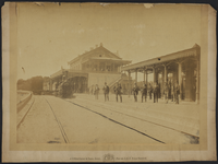 165803 Gezicht op het H.S.M.-station Baarn te Baarn, met links een stoomtrein en rechts enkele poserende personen.